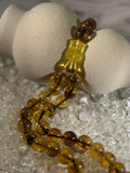 Close-up of natural amber beads with unique texture and polished surface – premium handmade prayer rosary.