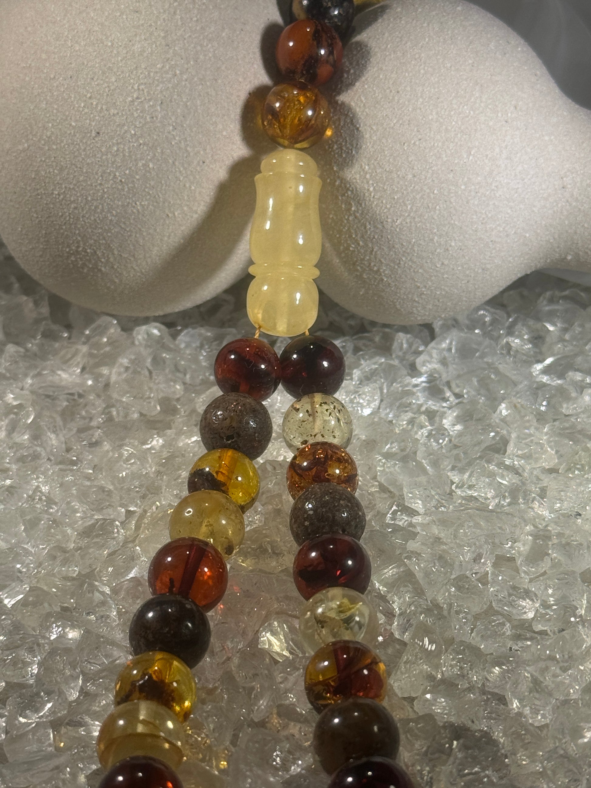 Close-up of natural amber beads with unique texture and polished surface – premium handmade prayer rosary.