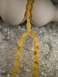 Close-up of natural amber beads with unique texture and polished surface – premium handmade prayer rosary.